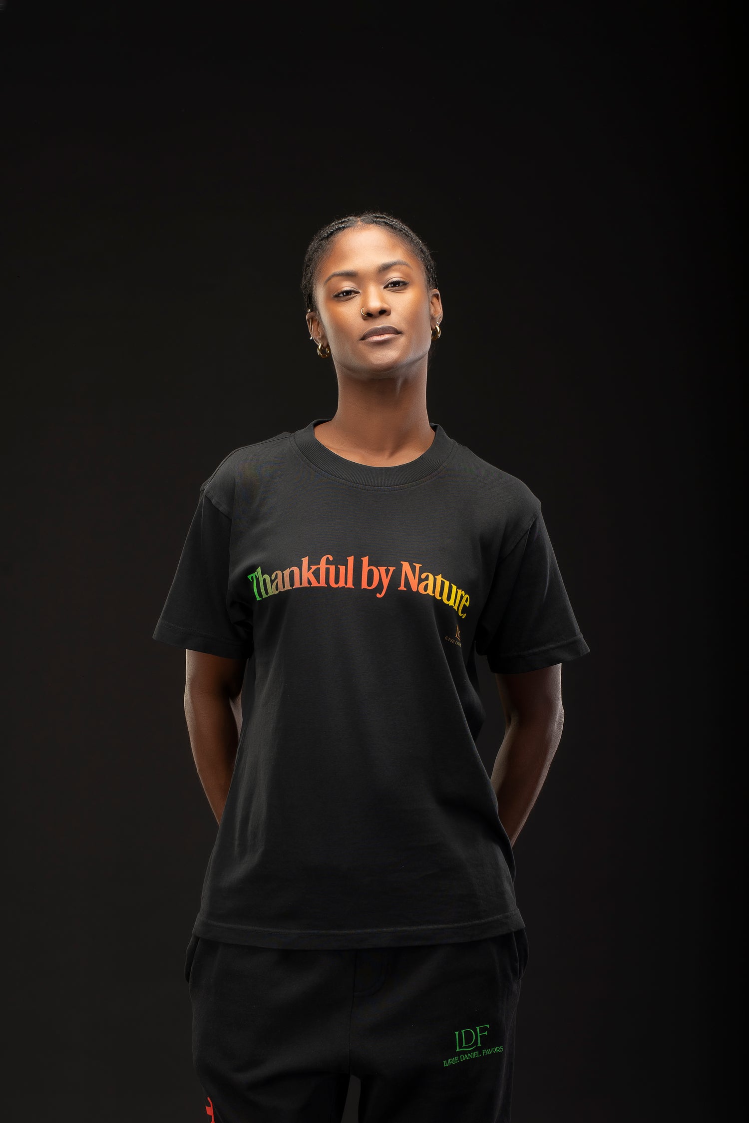 Woman wearing a black t-shirt with 'Thankful by Nature' text on a dark background
