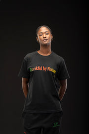 Woman wearing a black t-shirt with 'Thankful by Nature' text on a dark background