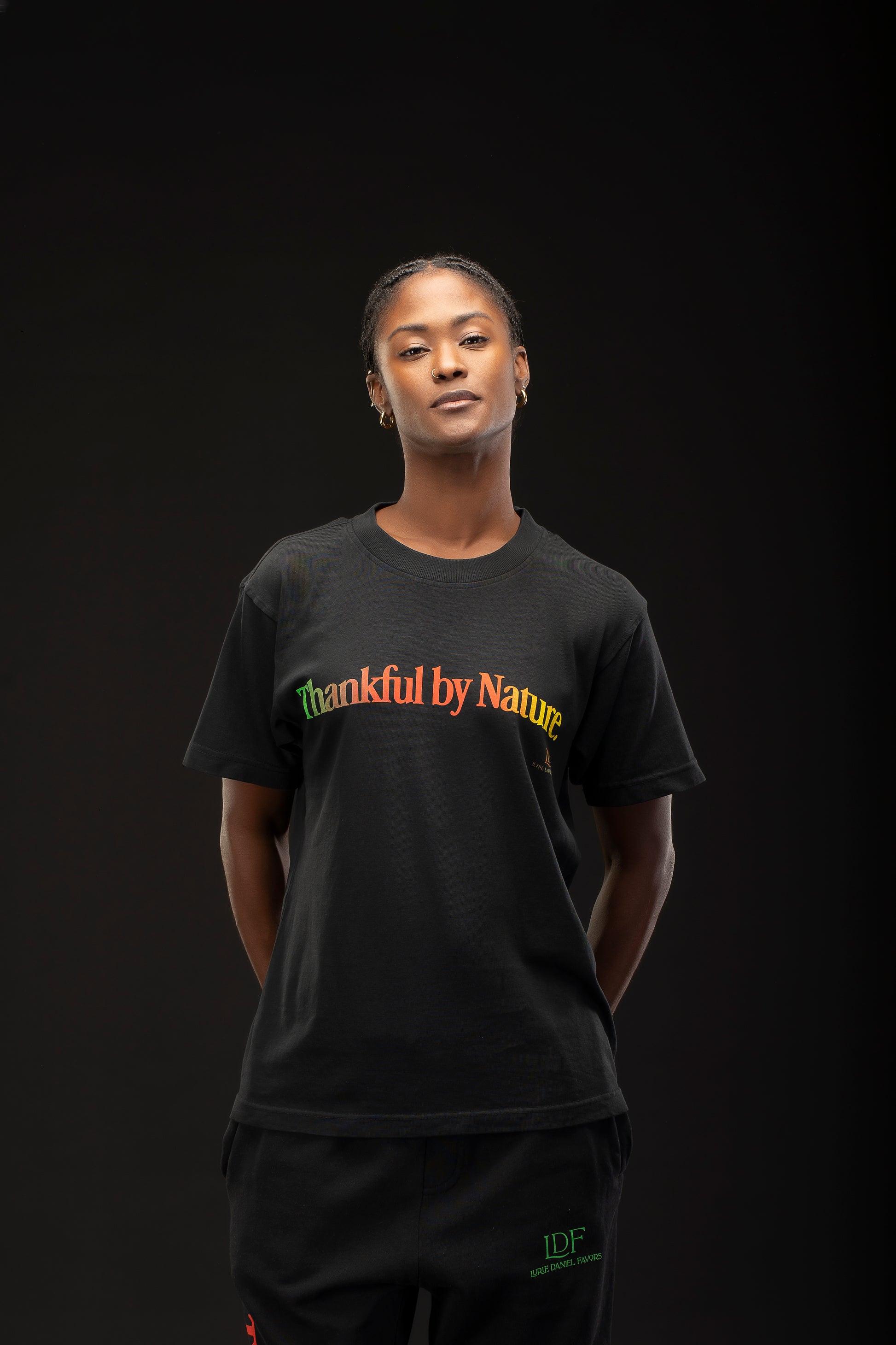 Woman wearing a black t-shirt with 'Thankful by Nature' text on a dark background