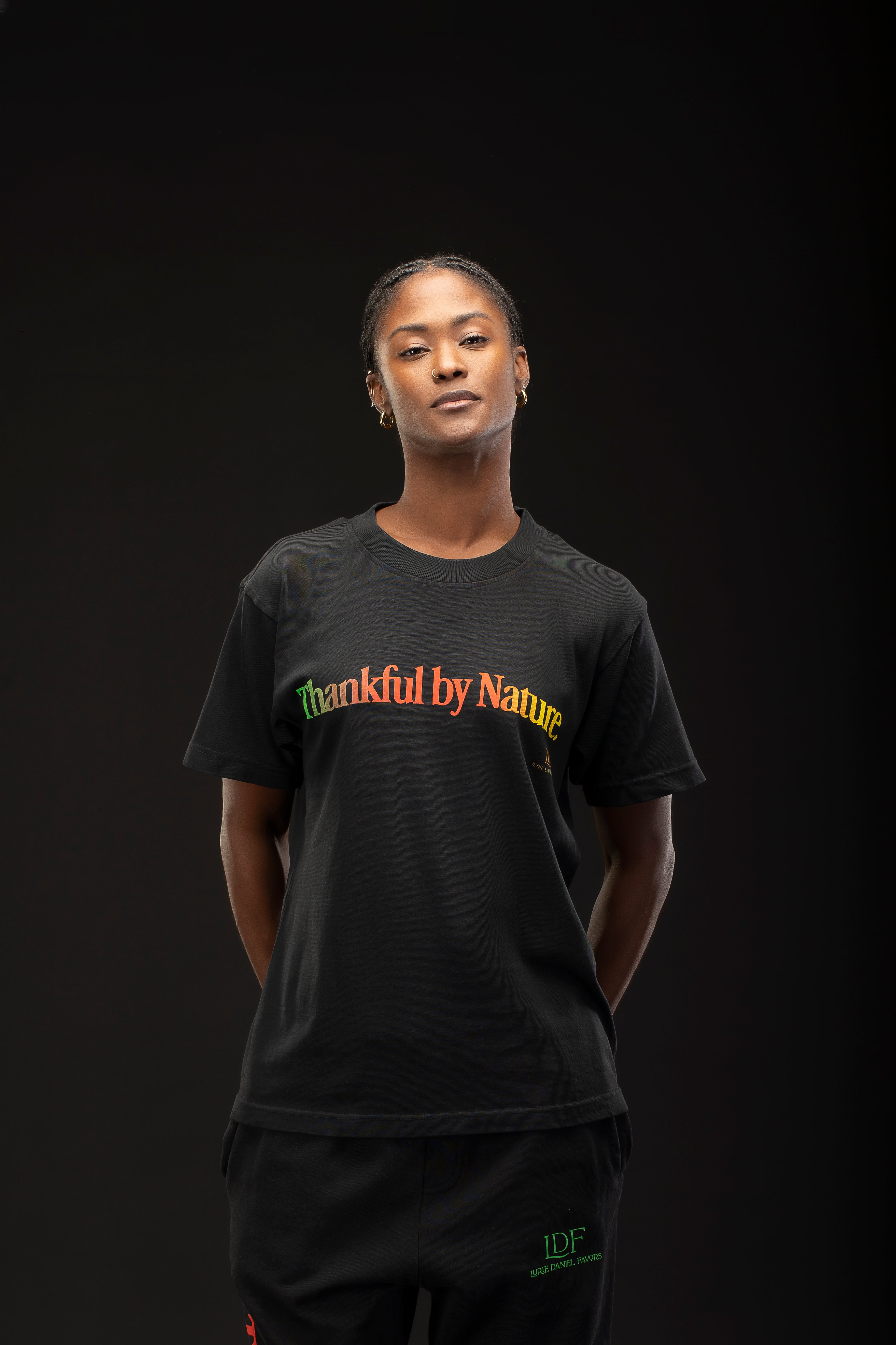Woman wearing a black t-shirt with 'Thankful by Nature' text on a dark background