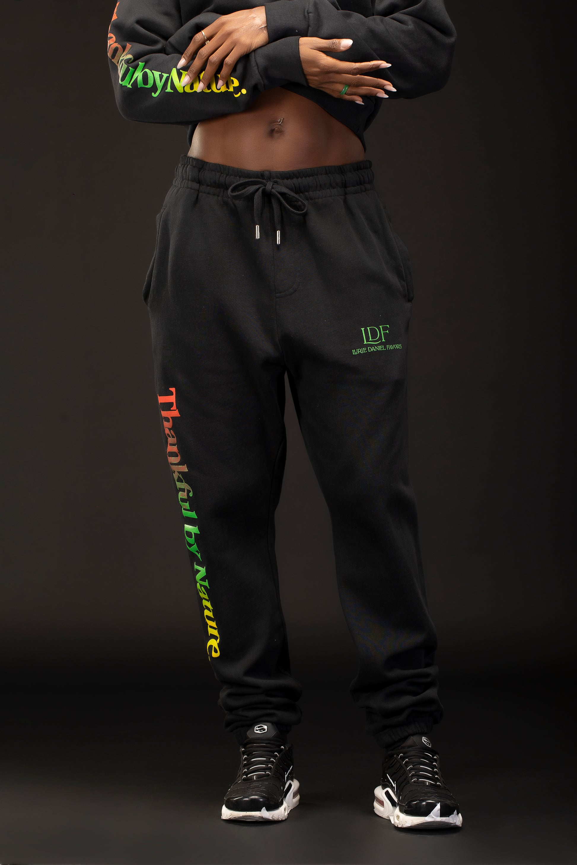Woman wearing black sweatpants with text on a dark background
