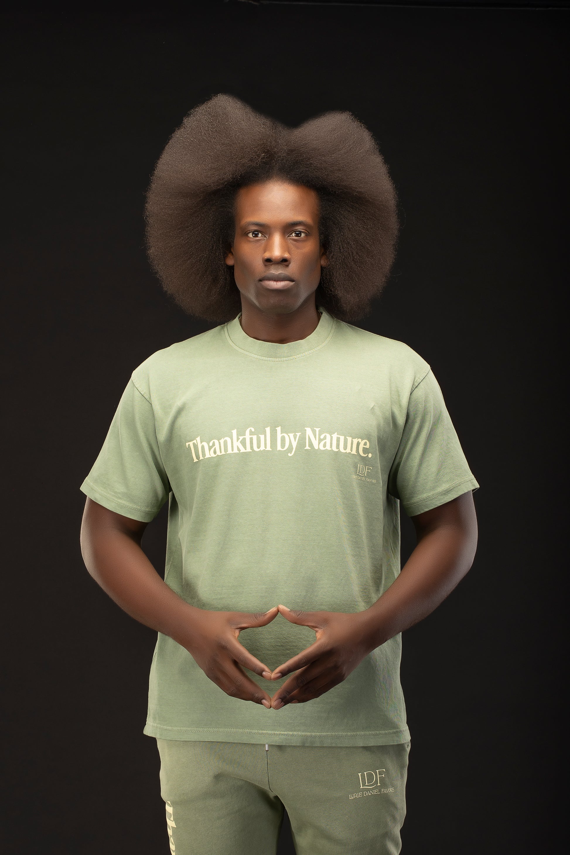 Person wearing a green t-shirt with 'Thankful by Nature' text on a black background