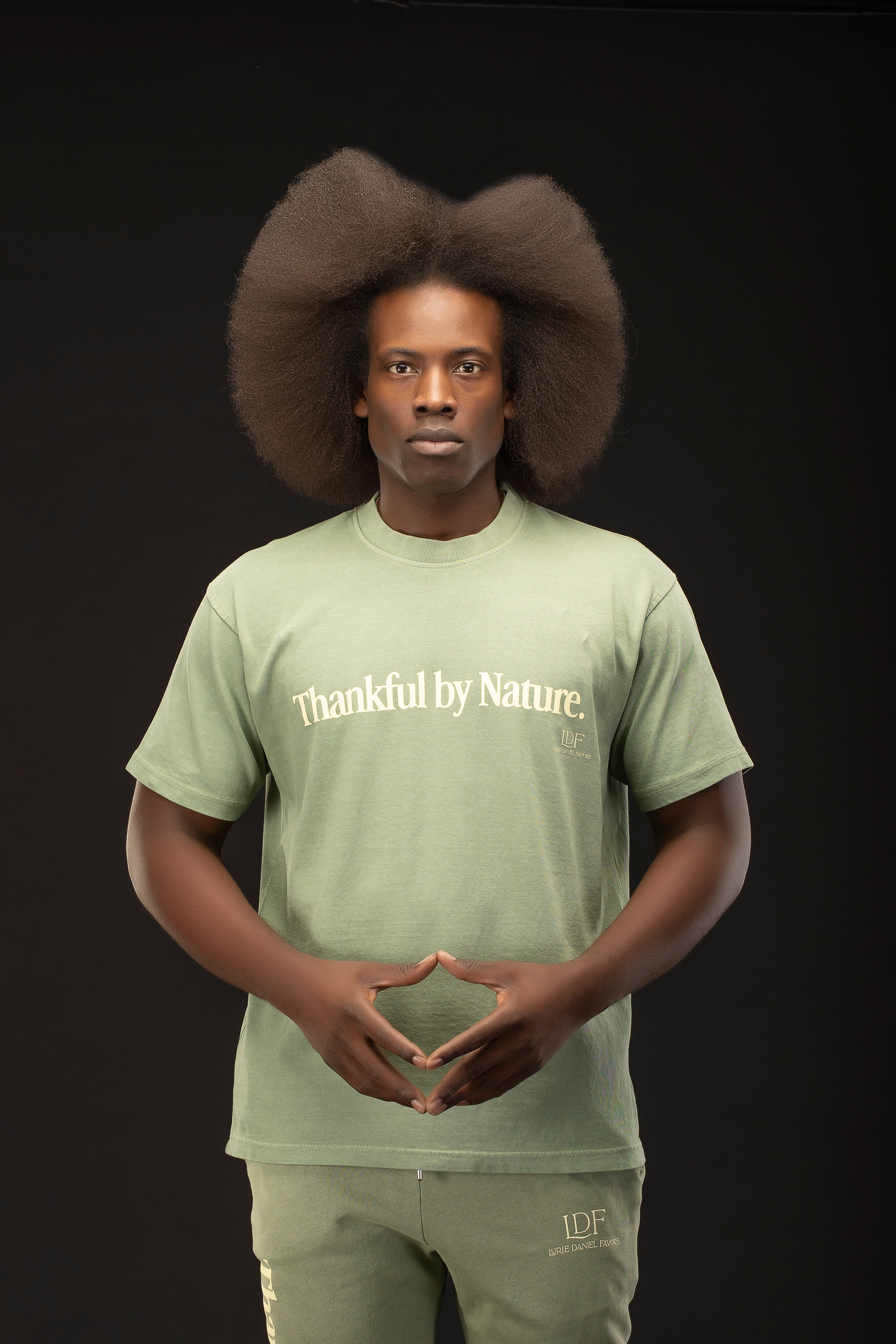 Person wearing a green t-shirt with 'Thankful by Nature' text on a black background