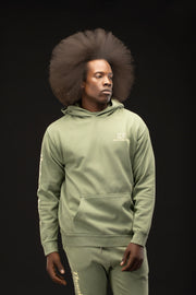 Man wearing a green hoodie and pants with a black background